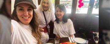 Image of three women posing for a selfie in a cafe